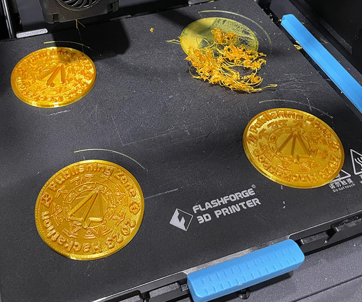 Four of the coins on the 3D printer platform with one failed.