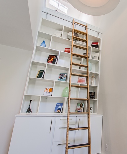 Photo of a library ladder providing access to high bookshelves in a narrow loft space.