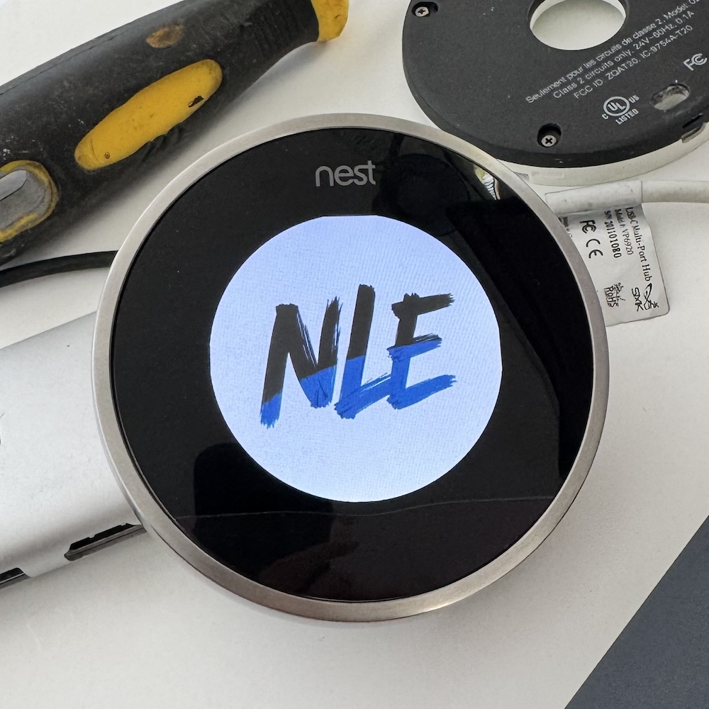 Photo of Nest thermostat with NLE logo on the screen